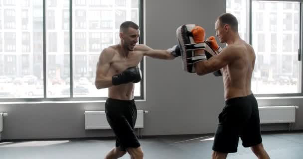 MMA bojovník cvičí své údery s trenérem ve zpomaleném filmu v tělocvičně, kickboxeři trénují, 4k 120fps Prores HQ — Stock video