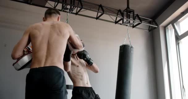 MMA μαχητής ασκεί απεργίες του με εκπαιδευτή σε αργή κίνηση στο γυμναστήριο, kickboxers προπόνηση, 4k 120fps Prores HQ — Αρχείο Βίντεο