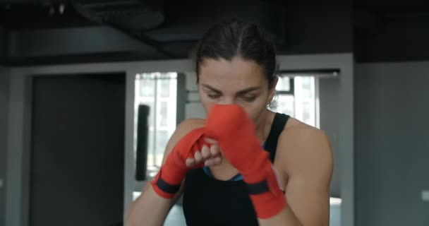 Mixed martial art fighter woman does shadow boxing to the camera in the fight club, female fighter is fighting with shadow, kickboxer training strikes in gym, 4k 120fps Prores HQ — Stock Video