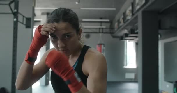 Smíšené bojové umění bojovnice dělá stínový box do kamery v klubu rváčů, ženské bojovnice bojuje se stínem, kickboxer trénink stávky v tělocvičně, 4k 120fps Prores HQ — Stock video