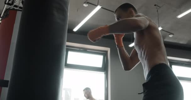 Боец смешанных единоборств бьет боксера кулаками и ногами в замедленной съемке, боец тренируется в боксерском клубе, 4k 60p Prores HQ — стоковое видео