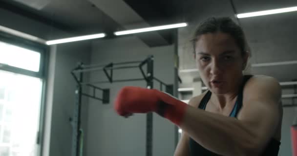 Mulher lutadora de arte marcial mista faz boxe sombra para a câmera no clube de luta, lutador feminino está lutando com sombra, kickboxer greves de treinamento no ginásio, 4k 120fps Prores HQ — Vídeo de Stock