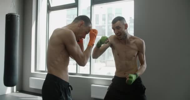 Deux kickboxeurs pratiquent leurs frappes et coups de poing au ralenti dans la salle de gym, les combattants des arts martiaux mixtes s'entraînent, QG 4k 120fps Prores — Video