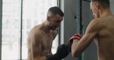 Boksör eldivenli dövüşçü antrenörüyle antrenman yapıyor. Kickboksörler antrenman yapıyor. 4k 120fps Prores Karargahı.