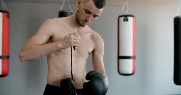 Fighter nasadí rukavice ve zpomaleném filmu, boxer v tělocvičně se připravuje na trénink, 4k Prores HQ 60 fps — Stock video
