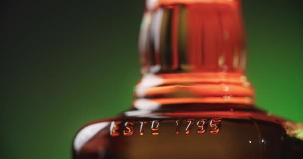 WARSAW, POLAND - SEPTEMBER 10, 2021: close up shot of the bottle of Jim Beam bourbon that is spinning around on the greenish background, 4k 60p Prores HQ — Stock Video