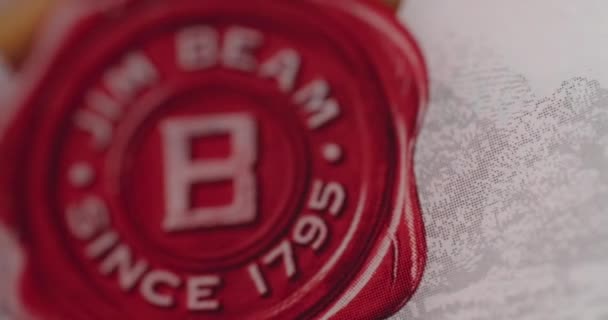 WARSAW, POLAND - SEPTEMBER 10, 2021: macro shot of the bottle of Jim Beam bourbon that is spinning around and the logo reveals, 4k 60p Prores HQ — Stock Video