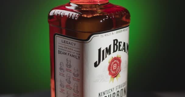 WAARSCHUWING, POLEN - SEPTEMBER 10, 2021: geïsoleerde fles Jim Beam bourbon draait rond op de groene achtergrond, 4k 60p Prores HQ — Stockvideo