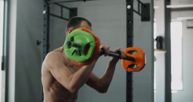 Sporcu halterle ağır çekimde egzersiz yapar, spor salonunda ağırlık ile kardiyo yapar, 4k 120 fps Prores HQ