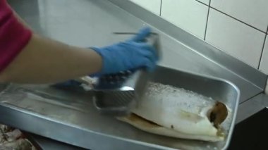 Aşçı balığı rendeyle temizler.
