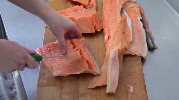 Kocken skär upp fisken i trä styrelsen med kniv i köket — Stockvideo