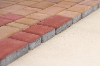 Kırmızı kaldırım döşeme kum üzerinde.