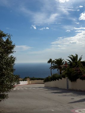 Cumbre del Sol-Adelfas, 1S, 03726 Benitachell, Alicante, İspanya. 20 Ekim 2025. Gün batımında mavi manzaralı palmiye ağaçları olan güzel manzara.,