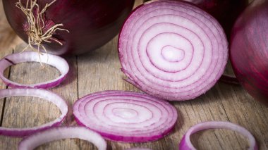 Red onions sliced on wooden background