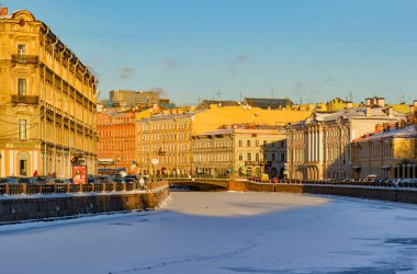 Güneşli bir kış akşamında St. Petersburg 'daki Moika Nehri seti boyunca yürü.. 