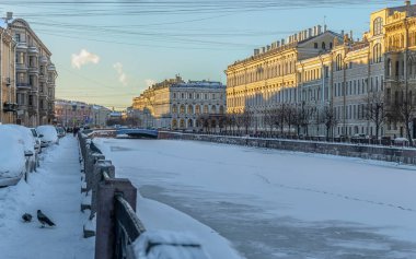 Güneşli bir kış akşamında St. Petersburg 'daki Moika Nehri seti boyunca yürü.. 
