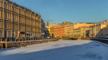 Güneşli bir kış akşamında St. Petersburg 'daki Moika Nehri seti boyunca yürü.. 