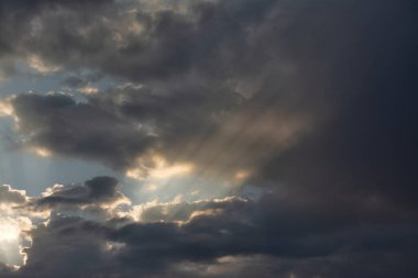 Şafak vakti bulutları delen güneş ışınları.