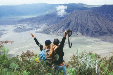 women standing looking  at volcano clipart