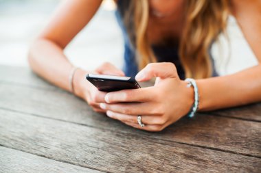 bir akıllı telefon tutan genç kız