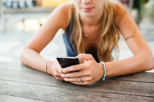 Chica joven sosteniendo un teléfono inteligente — Foto de Stock