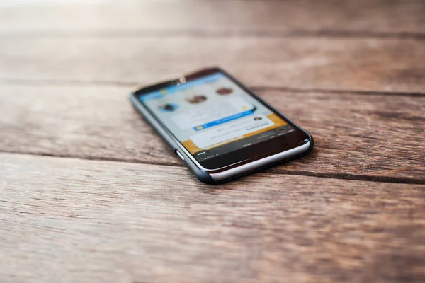 Chytrý telefon na dřevěný stůl pozadí — Stock fotografie