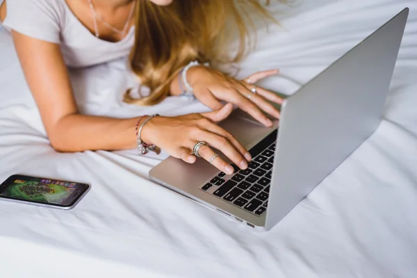 Menina loira com smartphone e laptop — Fotografia de Stock