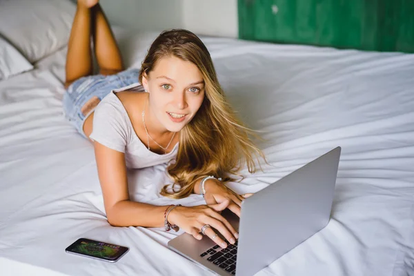 Chica rubia con smartphone y portátil — Foto de Stock