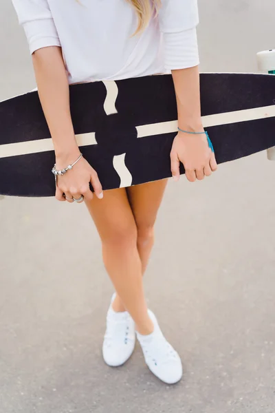 Mujer joven posando en la calle con monopatín — Foto de Stock