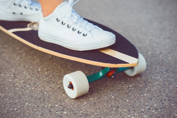 Jovem posando na rua com skate — Fotografia de Stock
