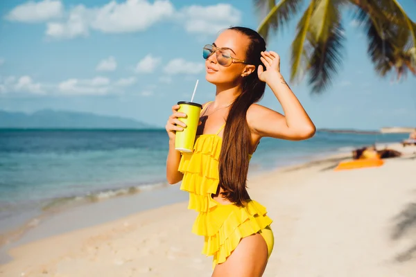 Krásná žena s koktejlem na pláži — Stock fotografie