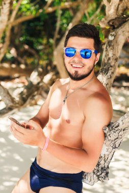 Genç adam telefonda konuşuyor.