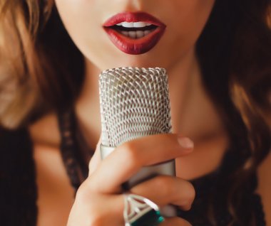 beautiful girl singing into  microphone