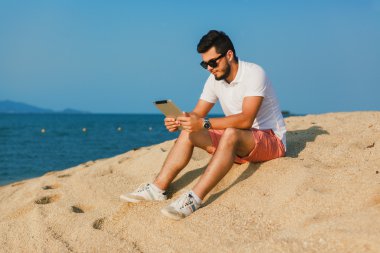 genç adam tablet üzerinde çalışan