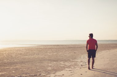 gün batımında güneş gözlüklü genç adam