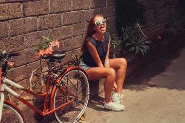 girl  posing with red bicycle