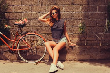 girl  posing with red bicycle