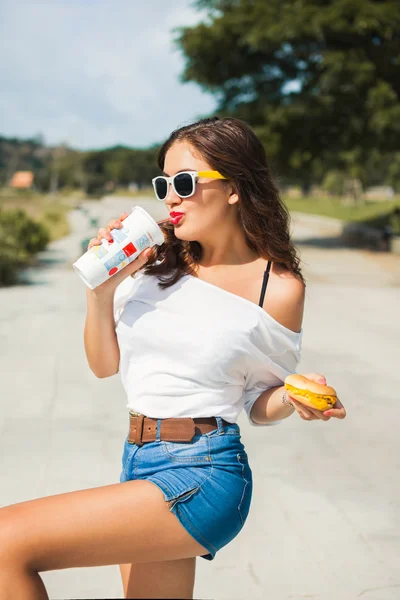 Menina em óculos comer fast food — Fotografia de Stock