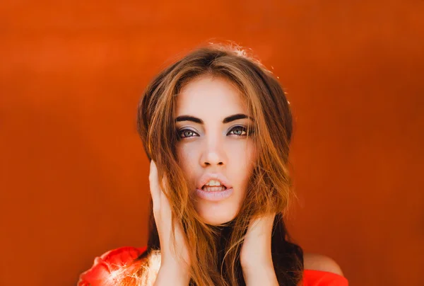 Chica joven contra la pared naranja — Foto de Stock