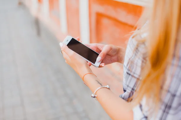 Mujer atractiva sosteniendo un teléfono inteligente — Foto de Stock