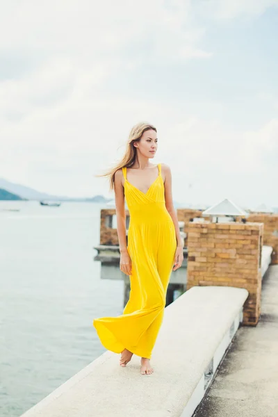 Ragazza in posa sul molo in abito giallo — Foto Stock