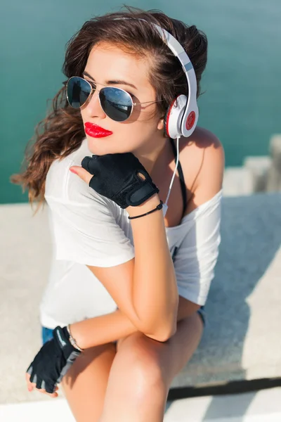 Gadis berkacamata hitam mendengarkan musik — Stok Foto