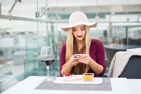 Donna che beve vino rosso con telefono — Foto Stock