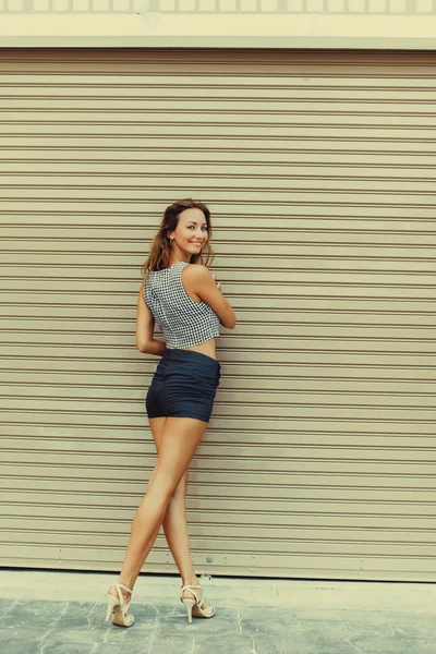 Beautiful brunette girl in shorts — Stock Photo, Image