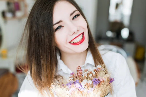 ブルネットの少女の花を持つ — ストック写真