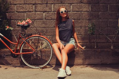girl  posing with red bicycle