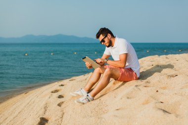 genç adam tablet üzerinde çalışan