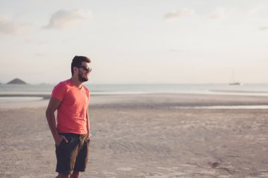 gün batımında güneş gözlüklü genç adam