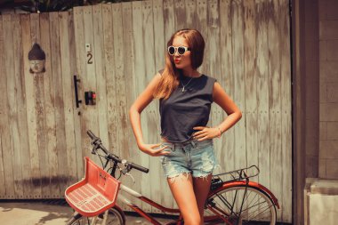 girl posing with  vintage bicycle