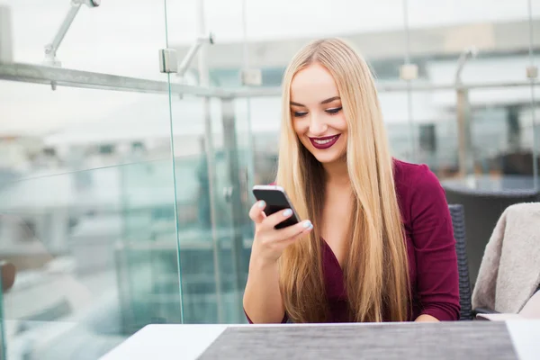 Woman at cafe with mobile phone — Stock Photo, Image